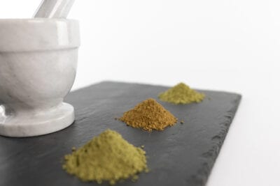 Kratom powder on tray with Mortar and Pestle