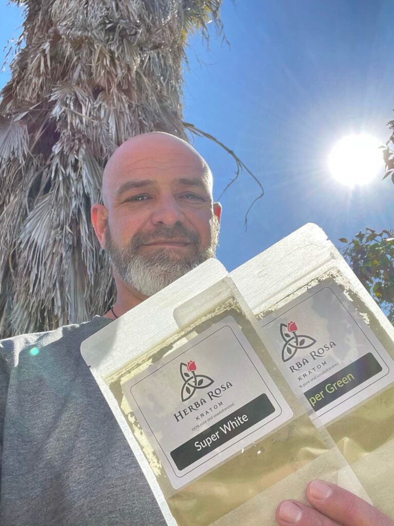 Man holding two bags of Herba Rosa kratom powder