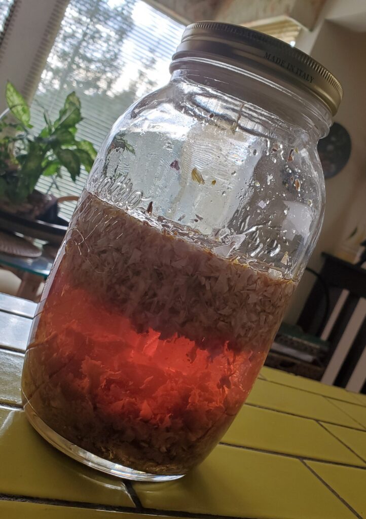 Jar of Blue Lotus Flower and Alcohol mixture, with an amber hue